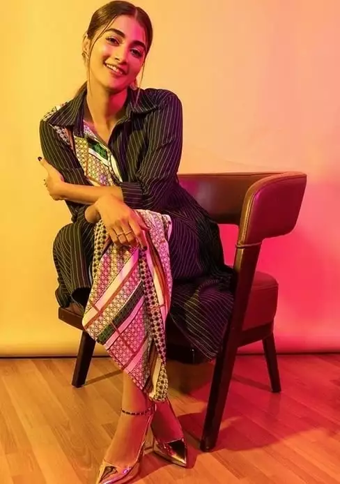 pooja hegde in a black dress on the chair